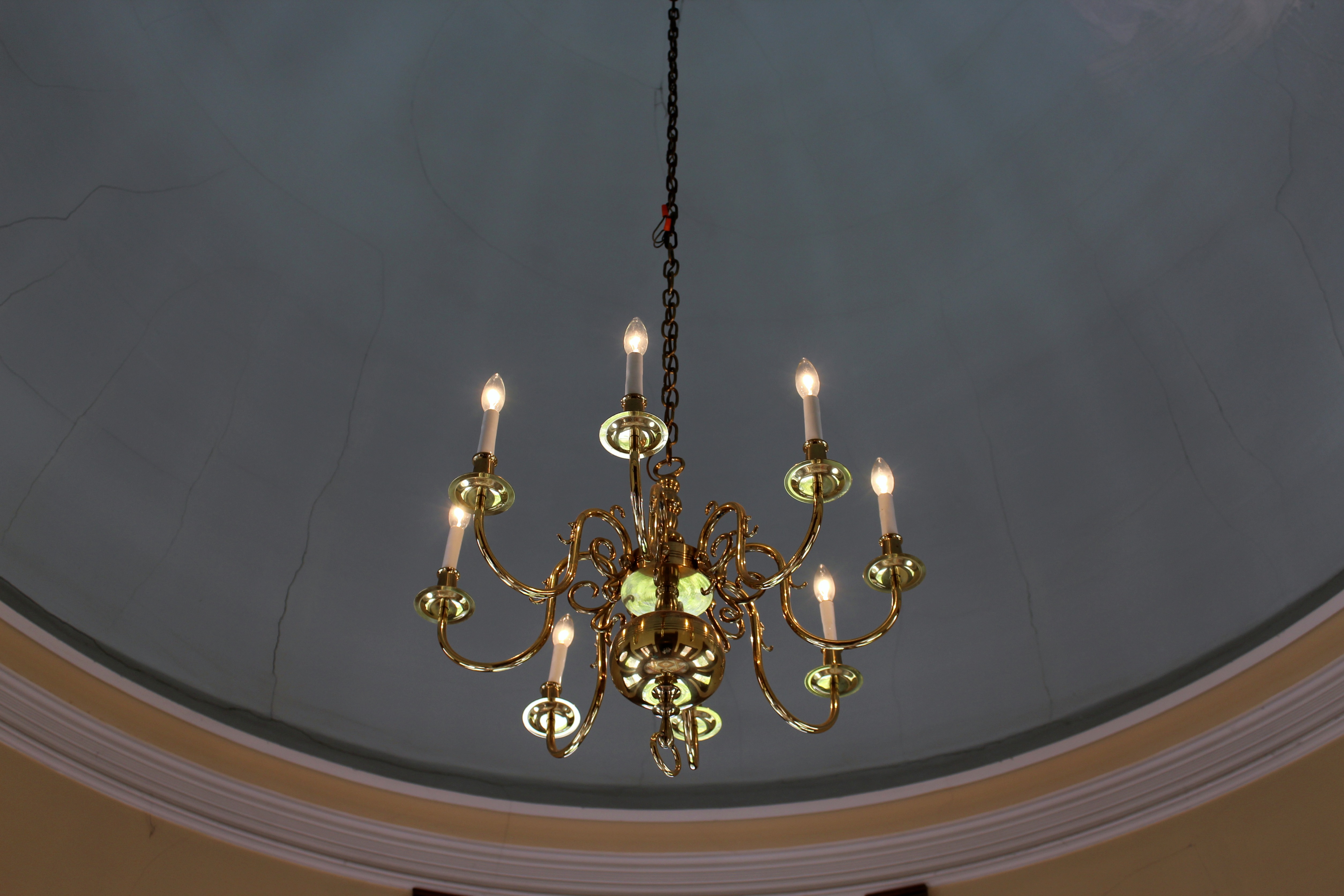 Luxe Gold Chandelier Set Against a Crumbling Domed Ceiling